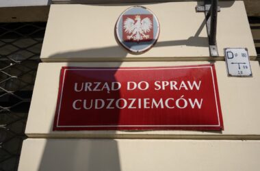 Czerwona tabliczka na budynku: urząd do spraw cudzoziemców