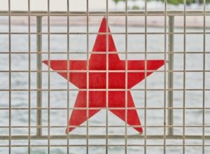 Czerwona gwiazda za kratami przypominającymi więzienne