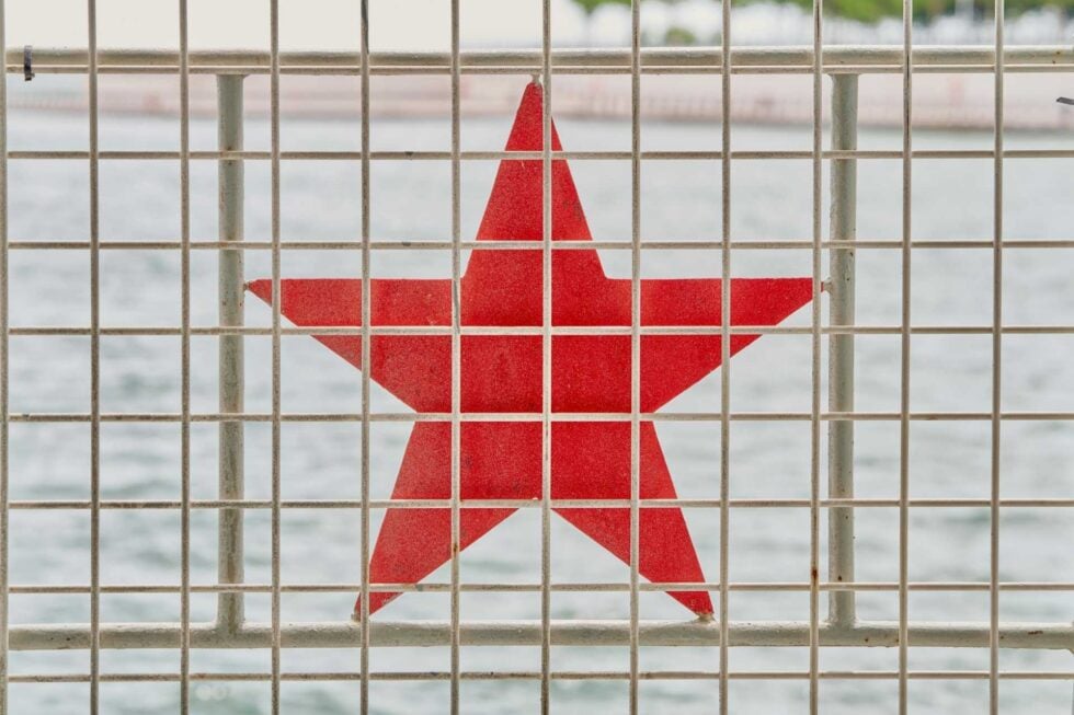 Czerwona gwiazda za kratami przypominającymi więzienne