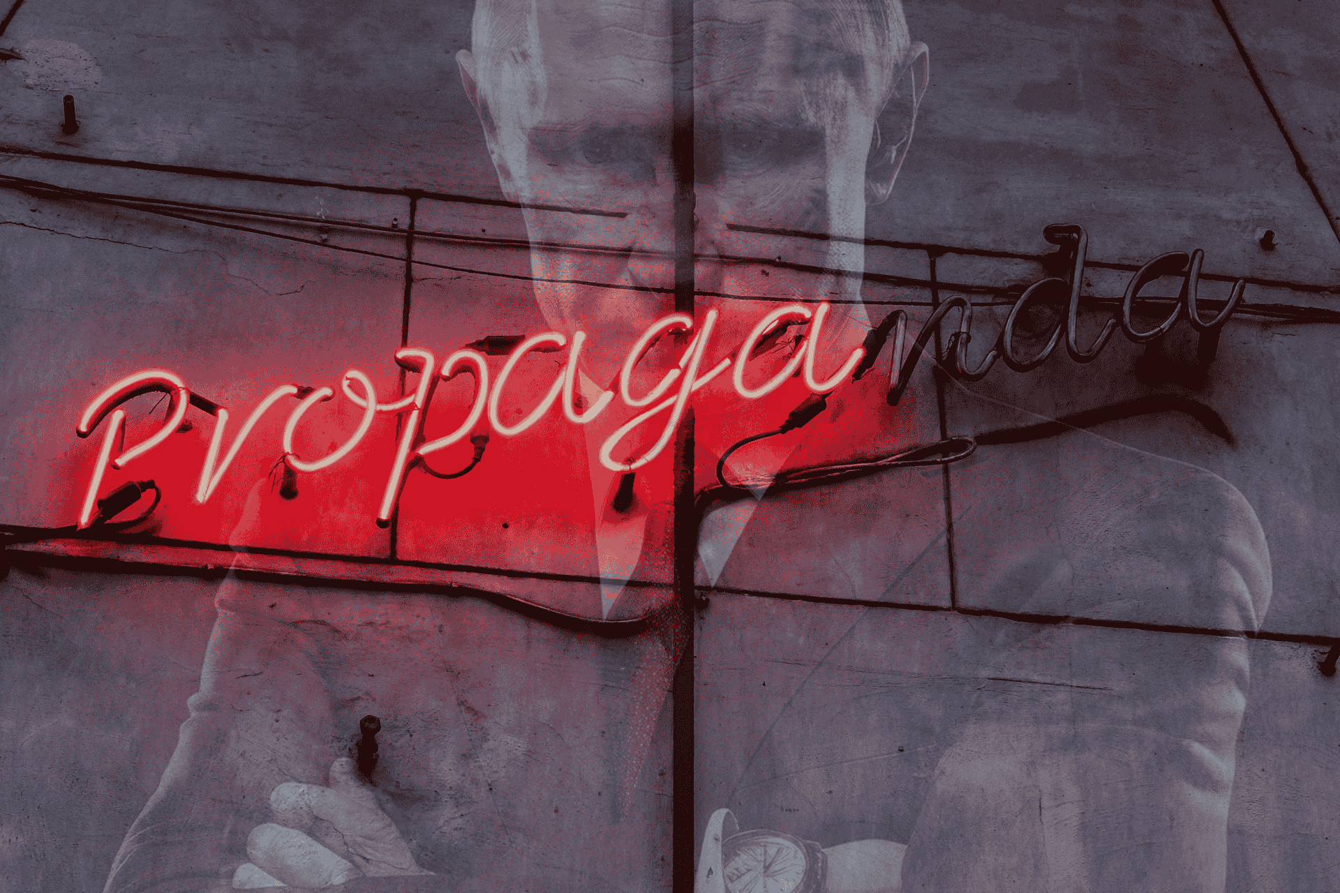 Wiszący na ścianie czerwony neon z napisem „propaganda”, przebijający przez ścianę wizerunek Władimira Putina