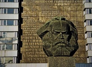 Pomnik Karla Marxa w Chemnitz: kamienna statua głowy na tle bloków mieszkalnych