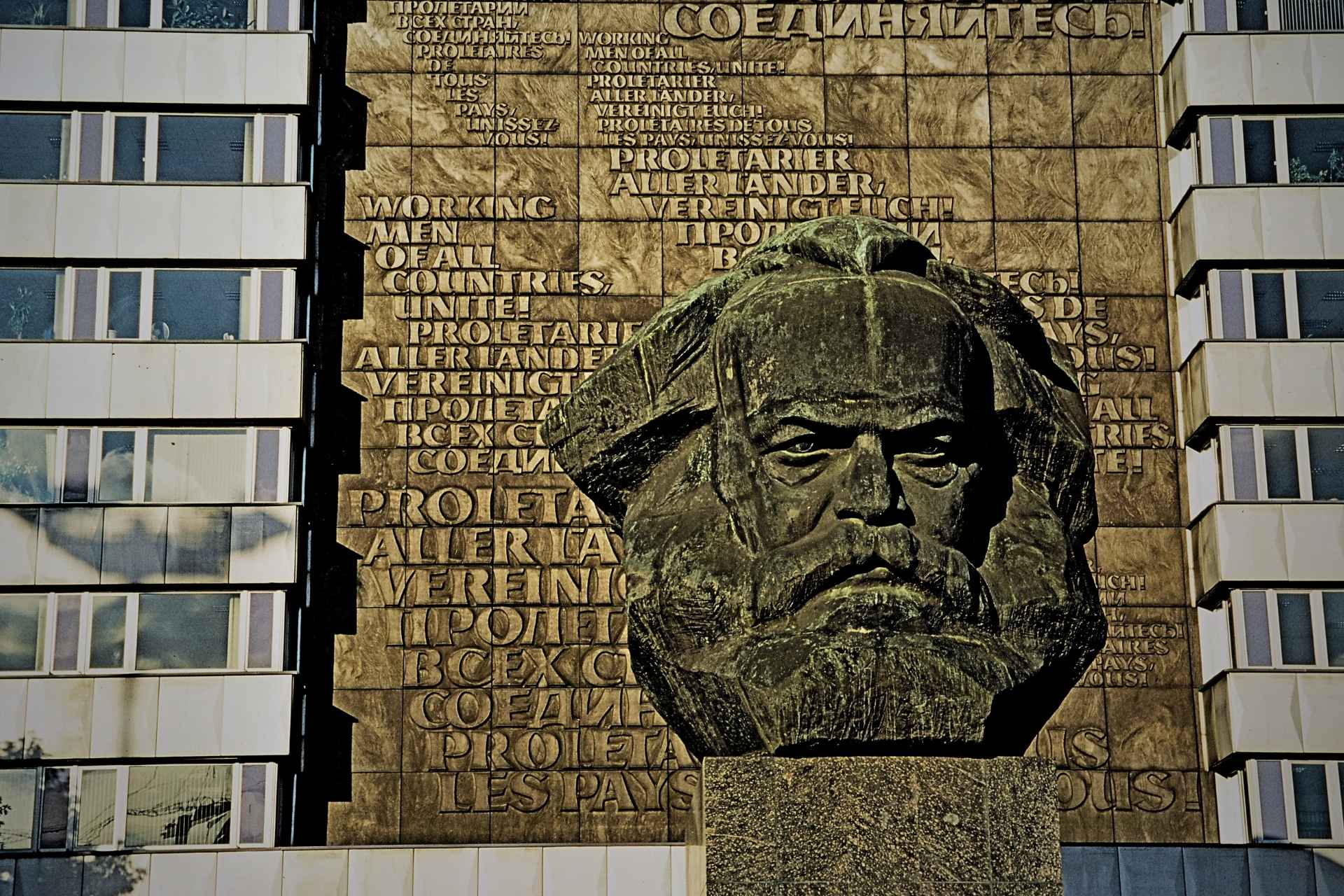 Pomnik Karla Marxa w Chemnitz: kamienna statua głowy na tle bloków mieszkalnych