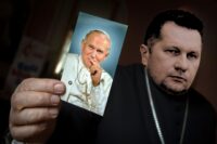 Fotomontaż przedstawiający Przemysława Czarnka ze zdjęciem Jana Pawła II w dłoni