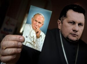 Fotomontaż przedstawiający Przemysława Czarnka ze zdjęciem Jana Pawła II w dłoni