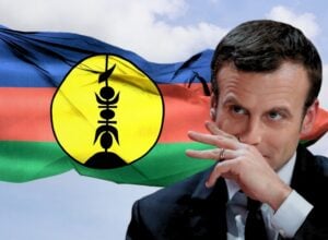 Emmanuel Macron, za nim powiewająca flaga Nowej Kaledonii
