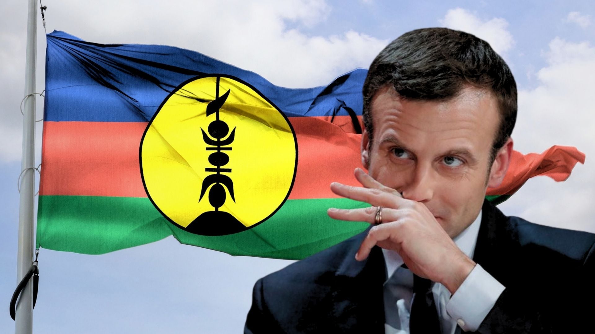 Emmanuel Macron, za nim powiewająca flaga Nowej Kaledonii