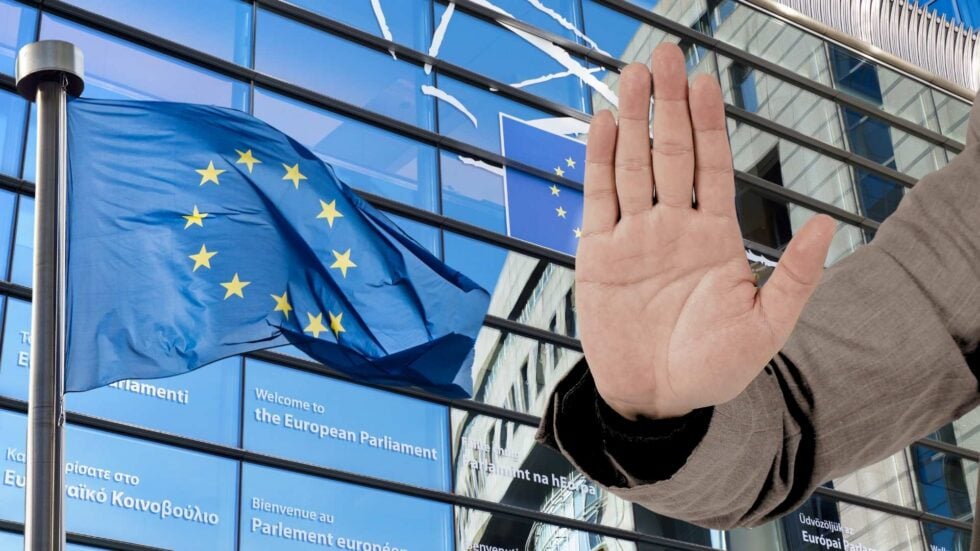 Oszklony budynek Parlamentu Europejskiego, z lewej flaga UE, z prawej dłoń pokazująca znak "stop"
