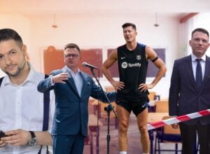 Four men at a press event in a classroom: a man in suspenders looks at his phone, a speaker at a mic, a runner in Barcelona kit, and an interviewer with a red mic.