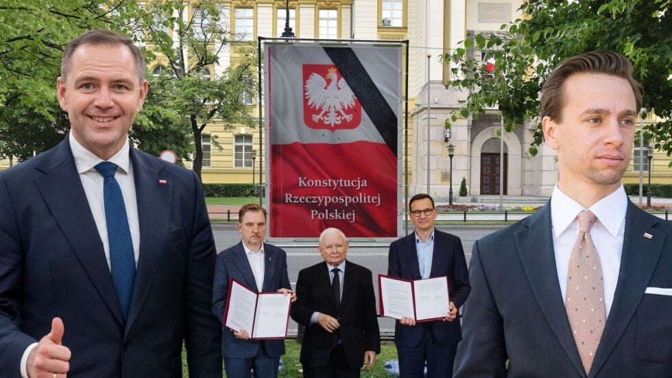 Five men in suits outdoors posing beside a banner that reads Konstytucja Rzeczypospolitej Polskiej near a government-style building.