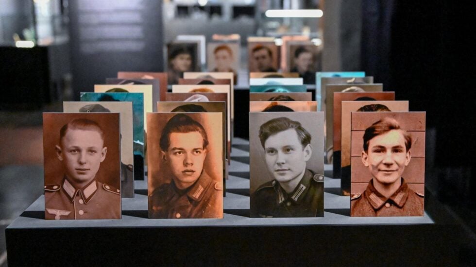 Row of vintage portrait cards of young men in military uniforms lined up on a display table in a museum setting.