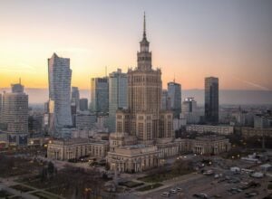 Sunset over Warsaw’s skyline, with the ornate Palace of Culture and Science in the foreground and modern towers to the left