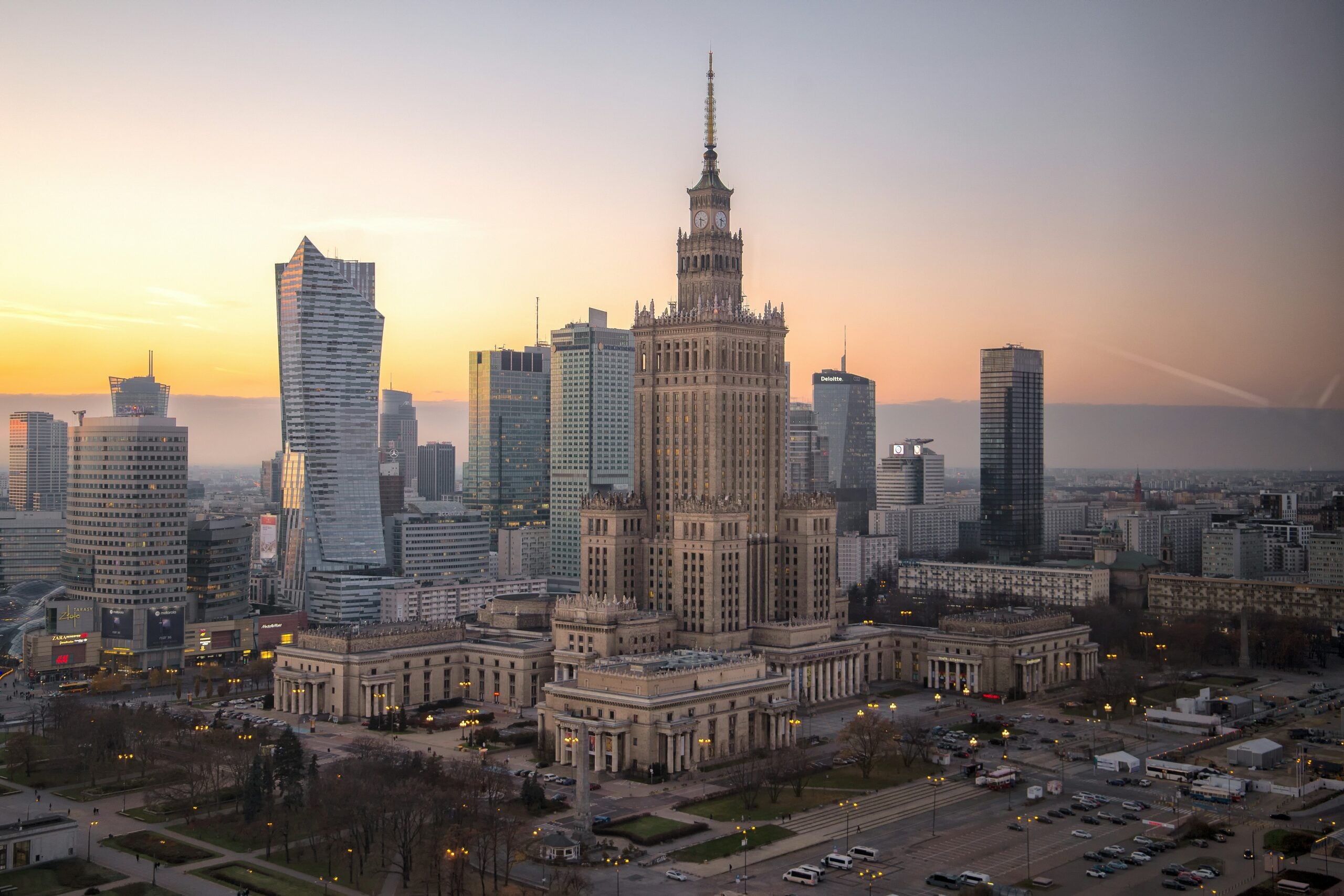 Sunset over Warsaw’s skyline, with the ornate Palace of Culture and Science in the foreground and modern towers to the left
