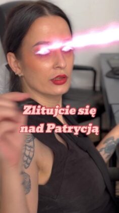 Woman with dark hair in a black top, bold red lipstick, tattooed arm, and pink laser beams coming from her eyes, with Polish caption overlay.
