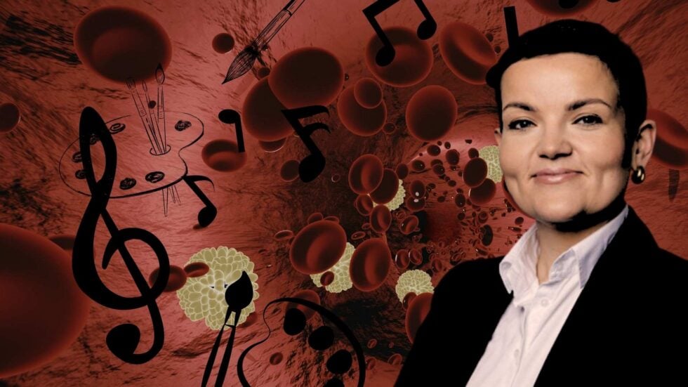 Smiling woman in professional attire against a red, science-themed background with blood cells and musical notes.