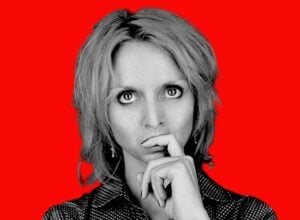 Close-up portrait of a thoughtful woman against a bold red background? no punctuation?