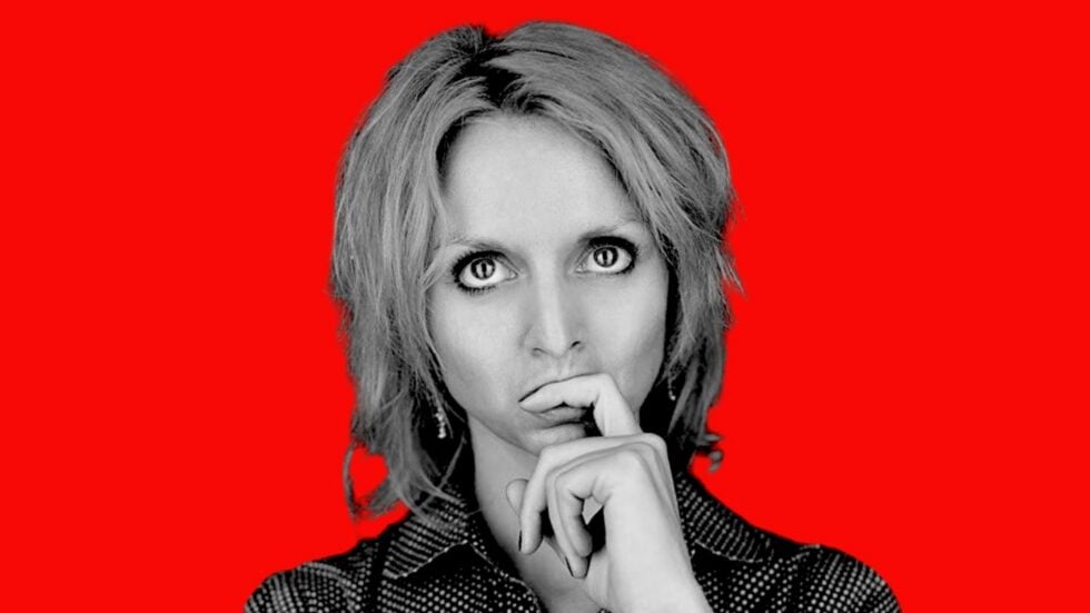 Close-up portrait of a thoughtful woman against a bold red background? no punctuation?