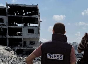 Ruiny miasta Gaza, po lewej dwóch mężczyzn w kamizelkach z napisem "Press"