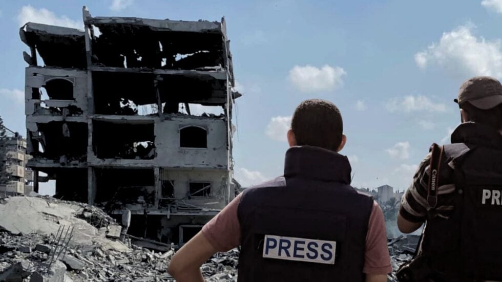 Ruiny miasta Gaza, po lewej dwóch mężczyzn w kamizelkach z napisem "Press"