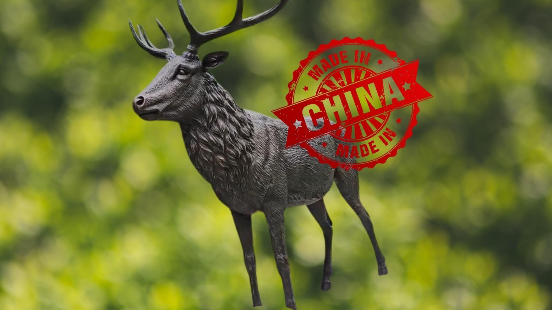 Olsztyński pomnik jelenia na zielonym leśnym tle, na nim duża czerwona plakietka "made in China"
