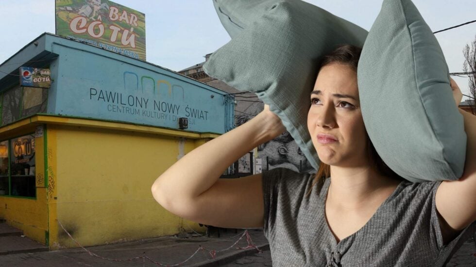 Woman shielding herself from the sun with two oversized gray pillows held over her head beside a yellow storefront and blue sign building.