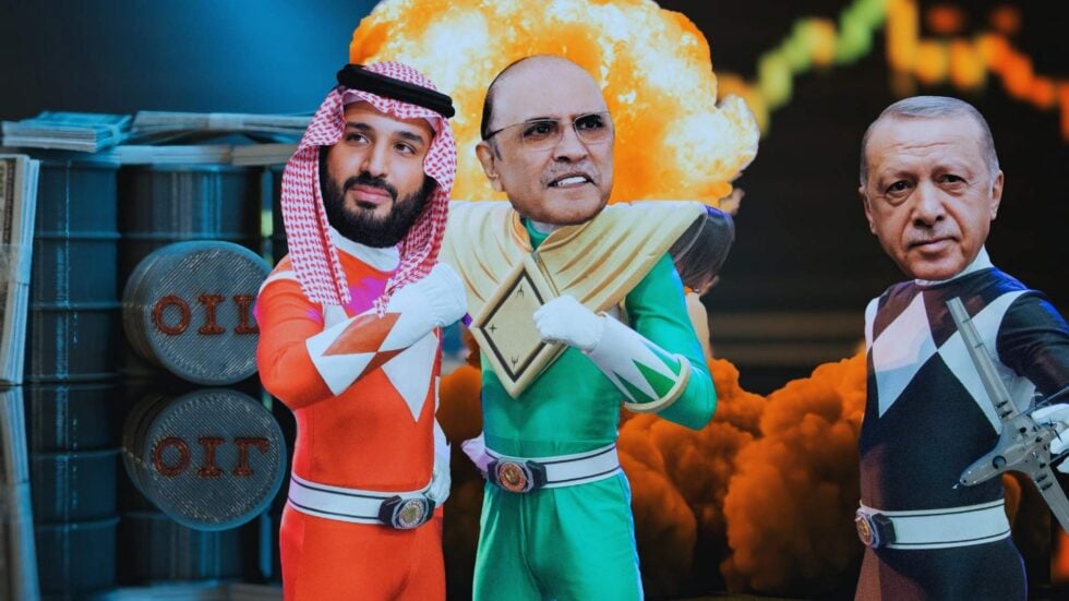 Three costumed performers stand together in front of a bright explosion backdrop, with oil drums stacked on the left.