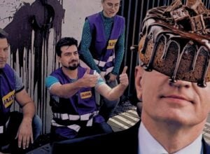 Członkowie ruchu klimatycznego Jazda pod domem Andziaks, za nimi sztuczna kupa rozbryzgana na ścianie, po prawej doklejony Jacek Jaśkowiak, któremu czekoladowy tort zasłania pół twarzy